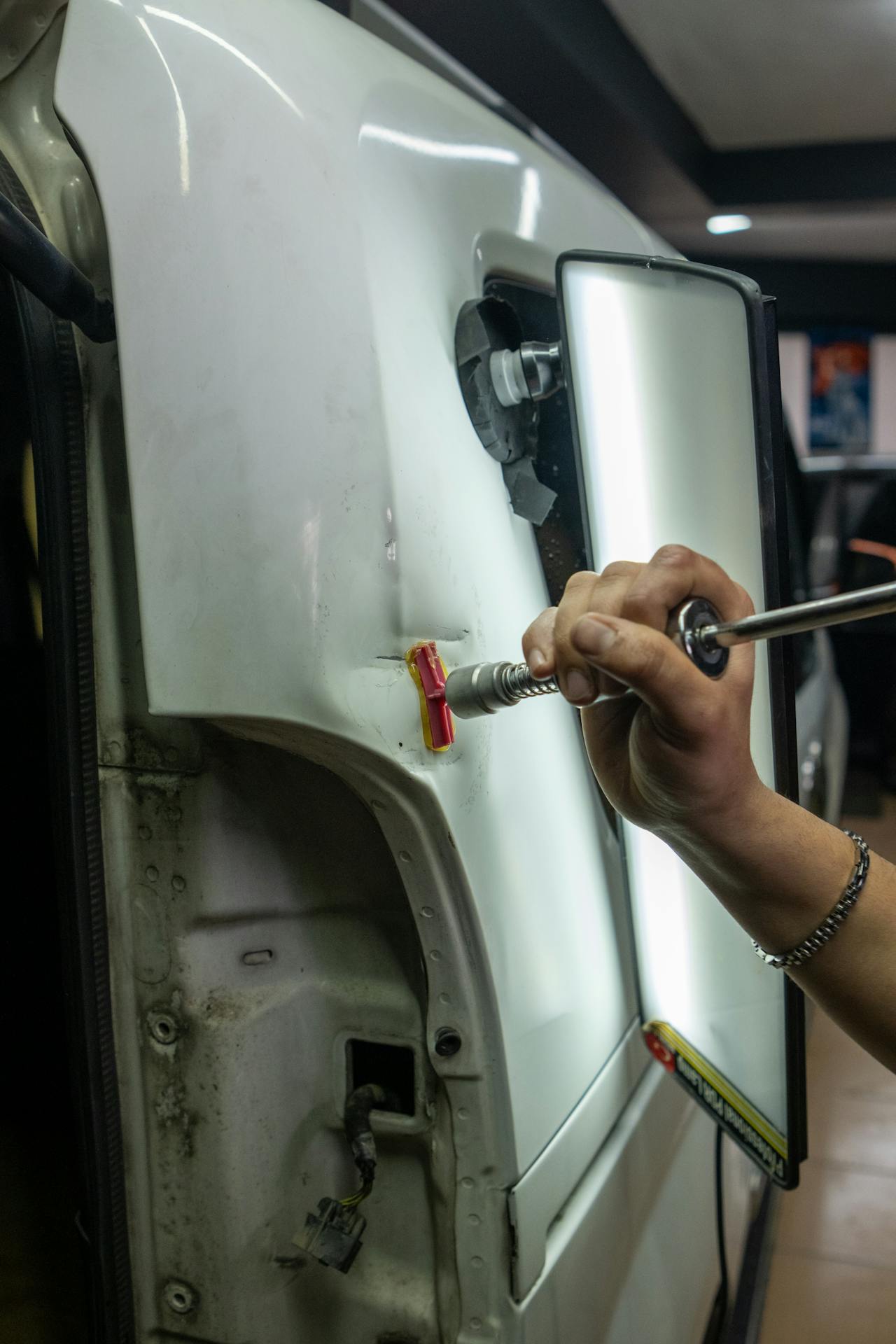 Technician inspecting collision damage on a vehicle body panel