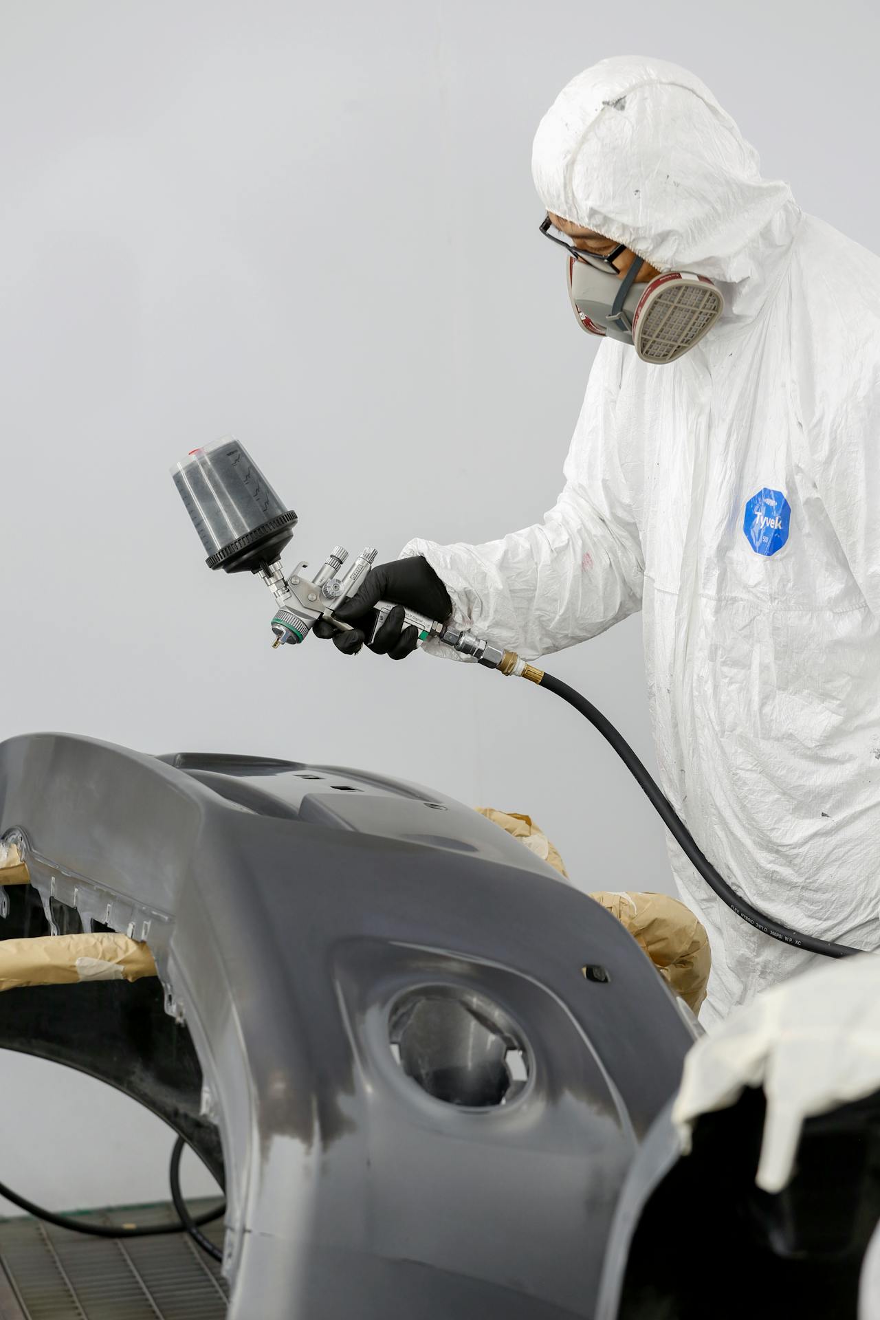 Freshly refinished glossy car body panel in a paint booth